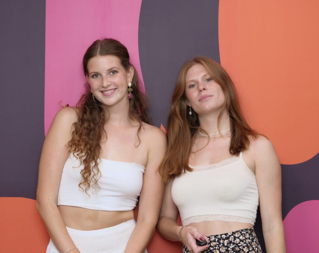 Zwei junge Frauen im Selfiestudio vor einer bunten Wand