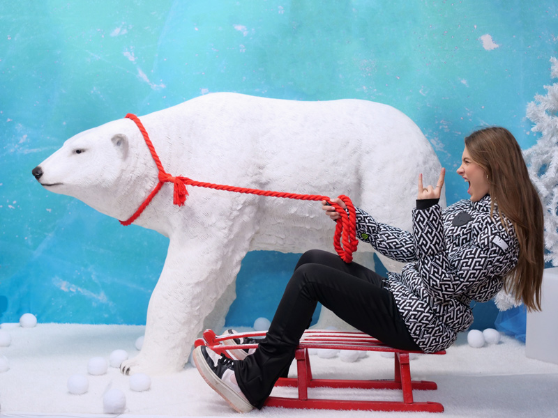 Mädchen auf Schlitten mit Eisbär im Selfie Studio bei Weihnachts Foto Shooting